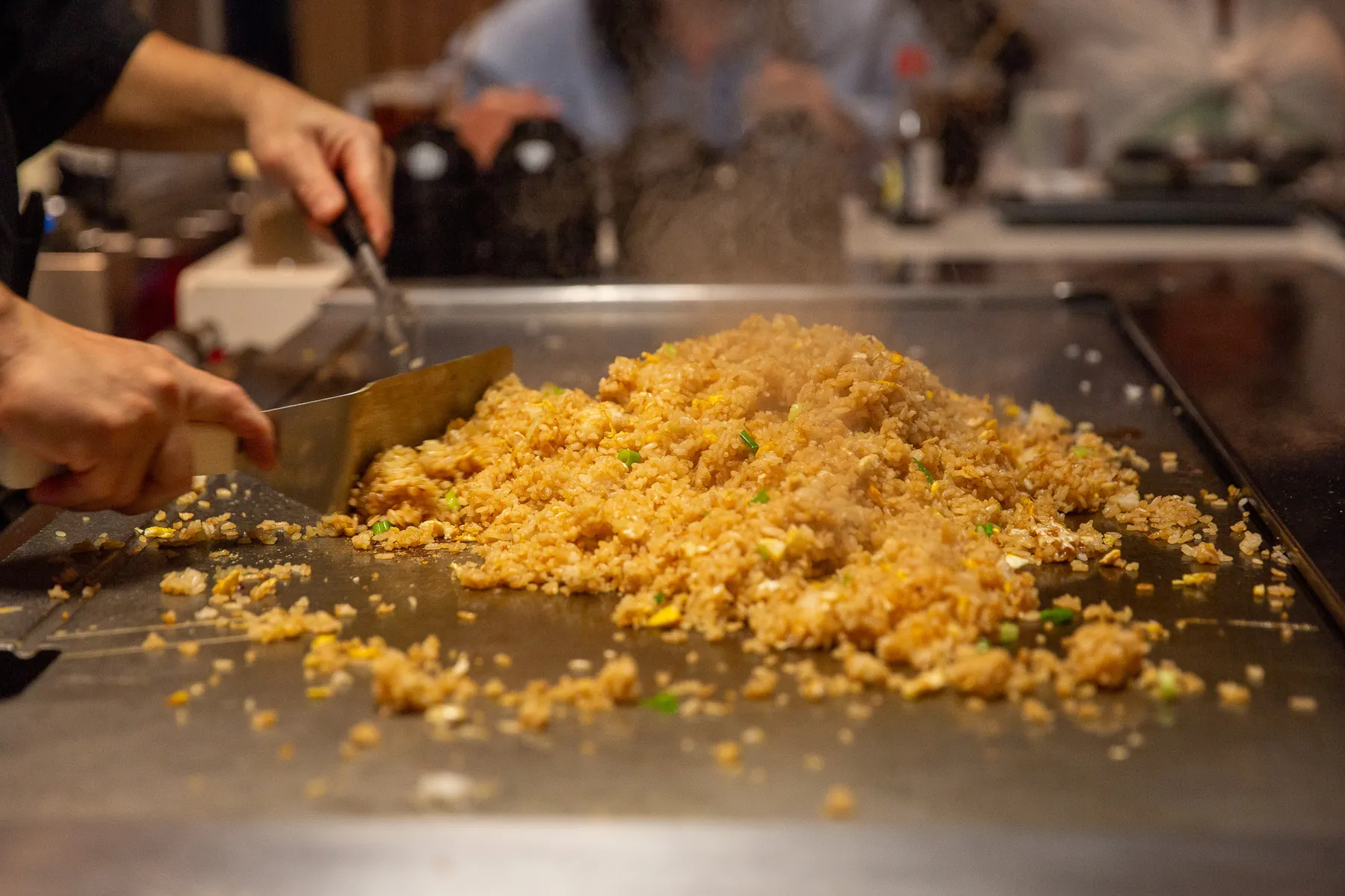 Chef preparing fried rice on a hibachi grill